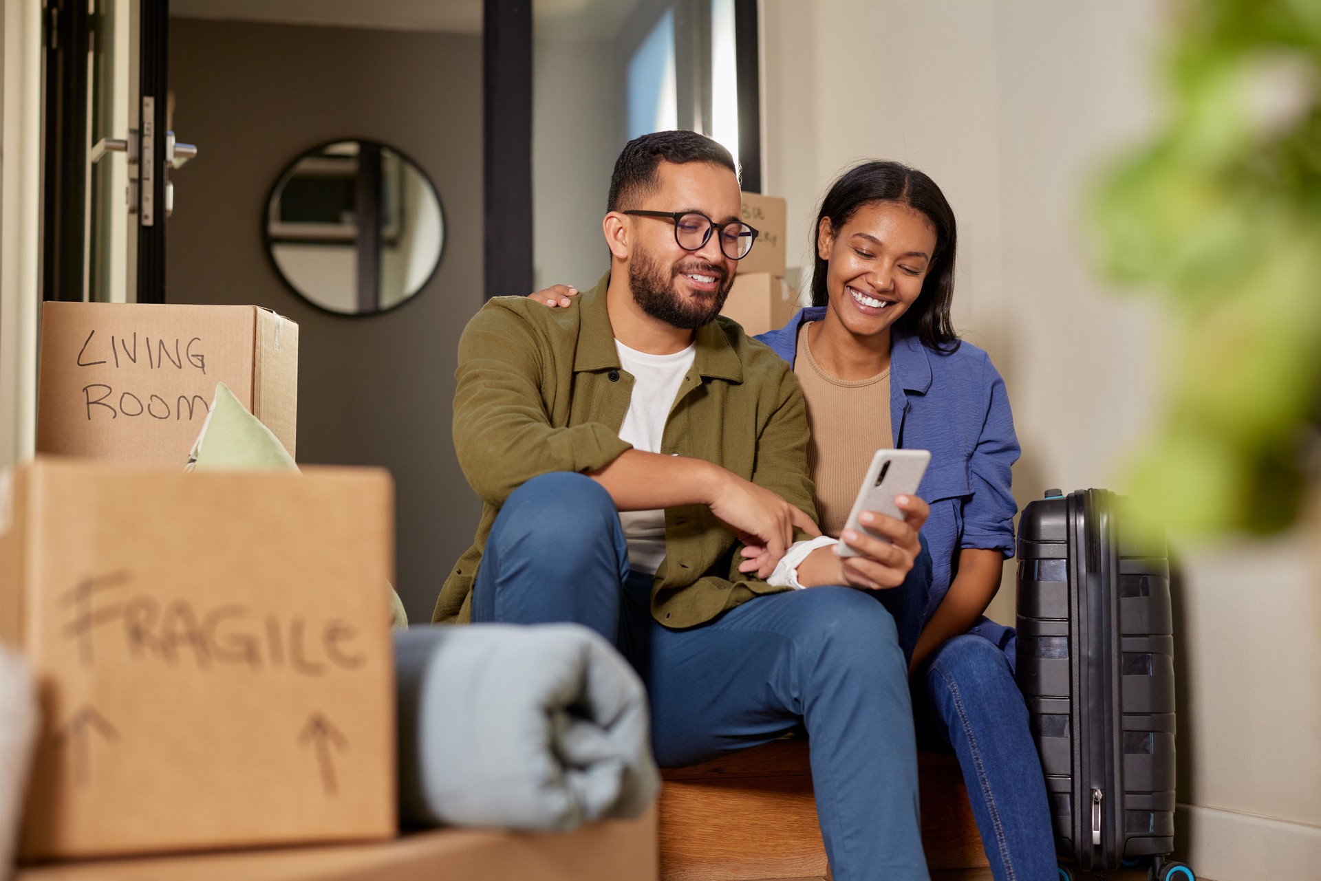 Middle eastern mid adult couple using phone after moving