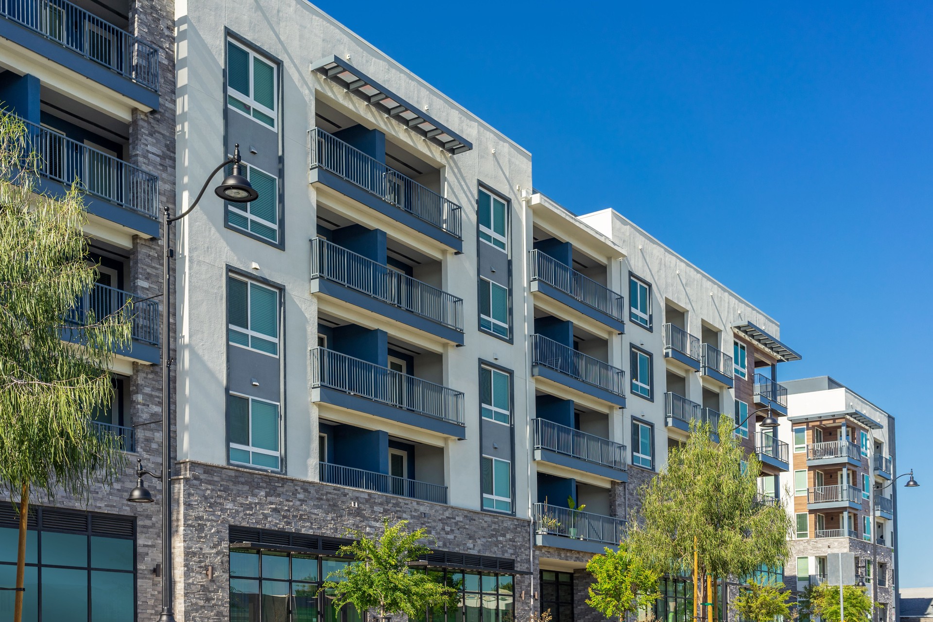 New modern apartment building with balconies and blue sky