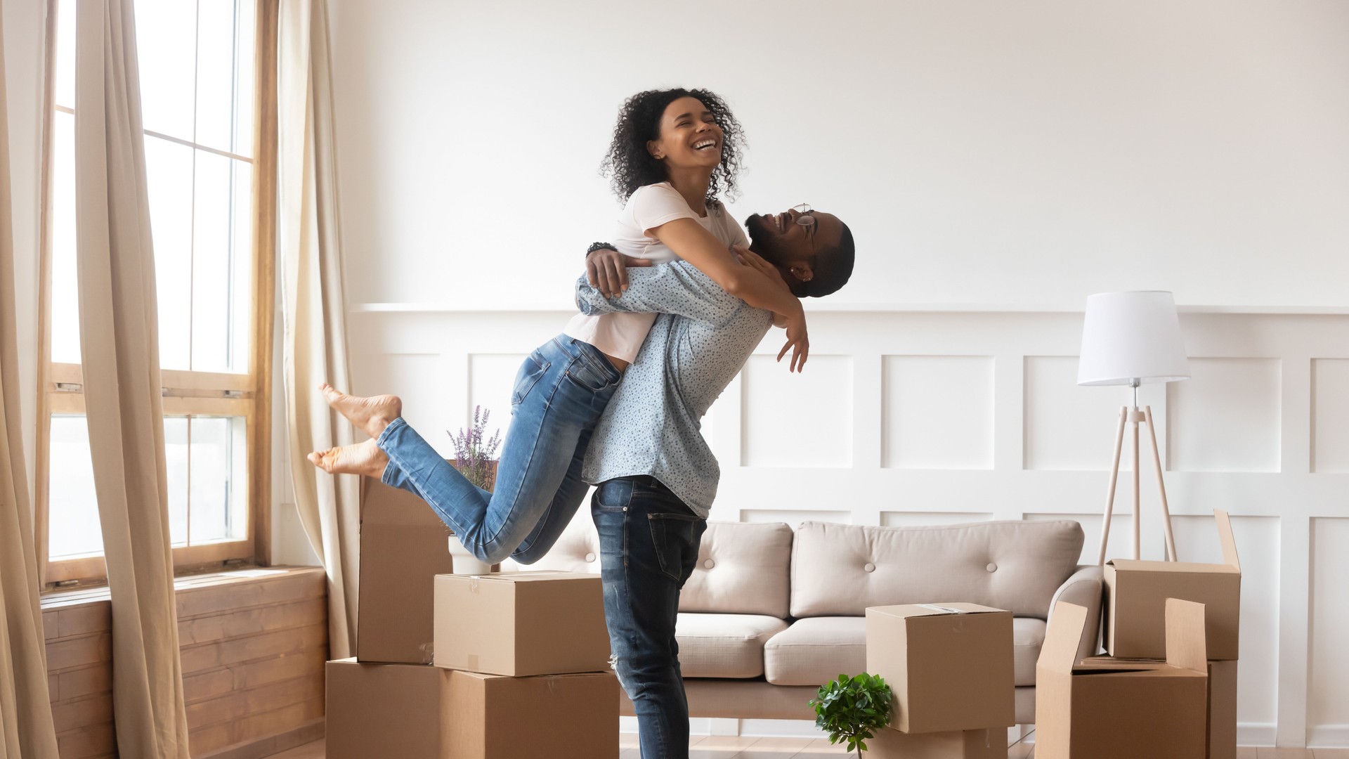 African husband lifting up wife happy family celebrating relocation day