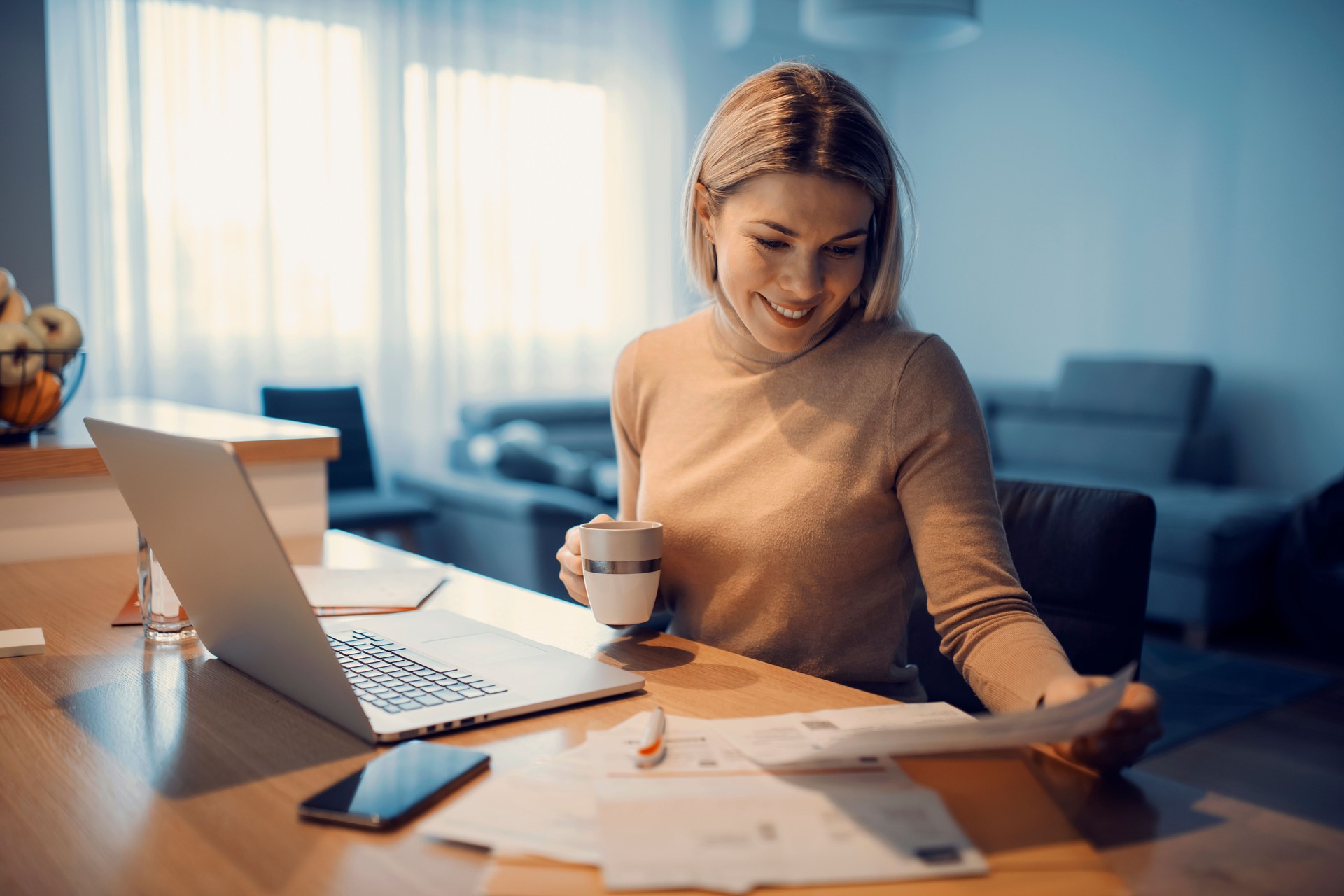 A happy woman doing household budget at her cozy home.