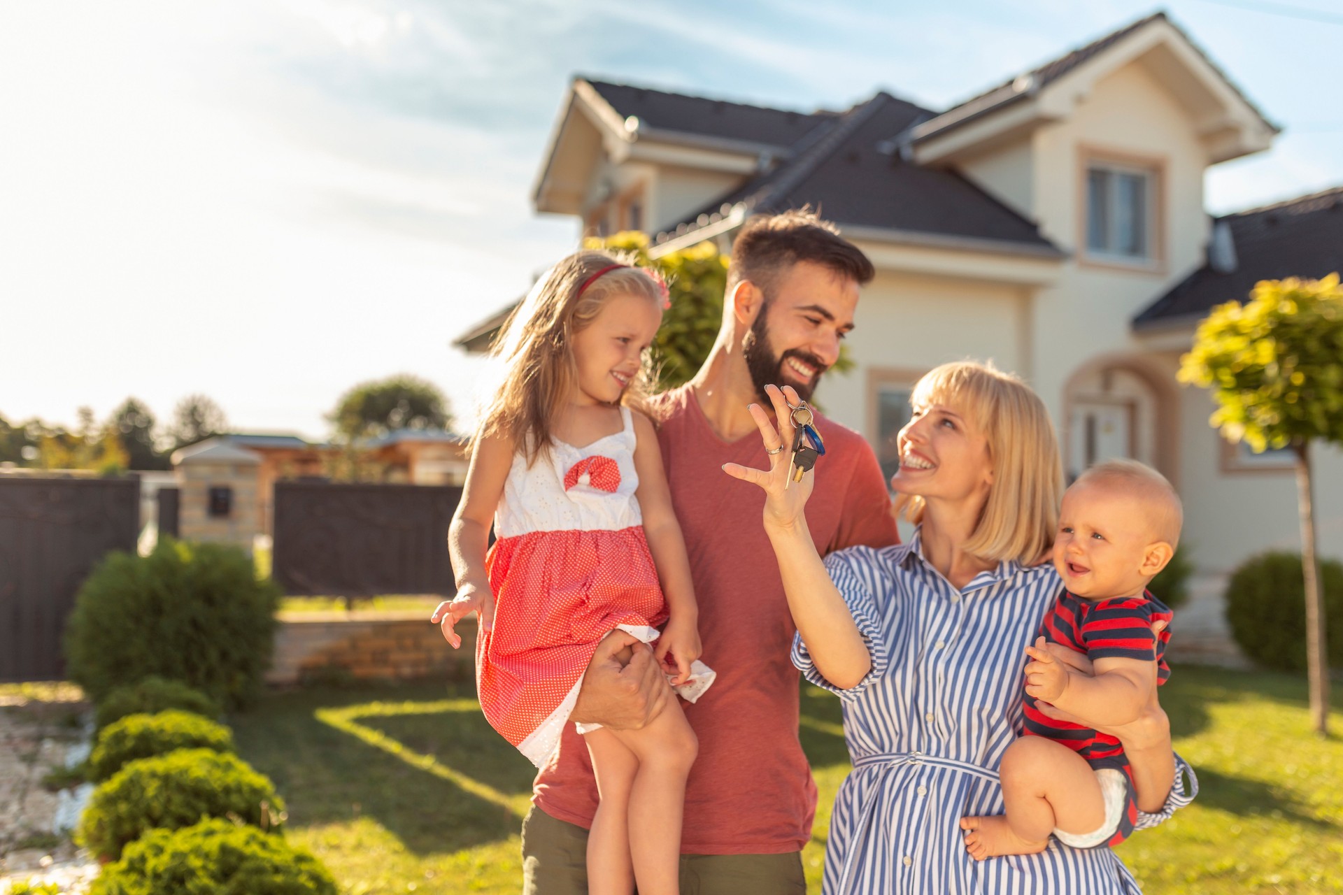 Family holding keys after buying a new house