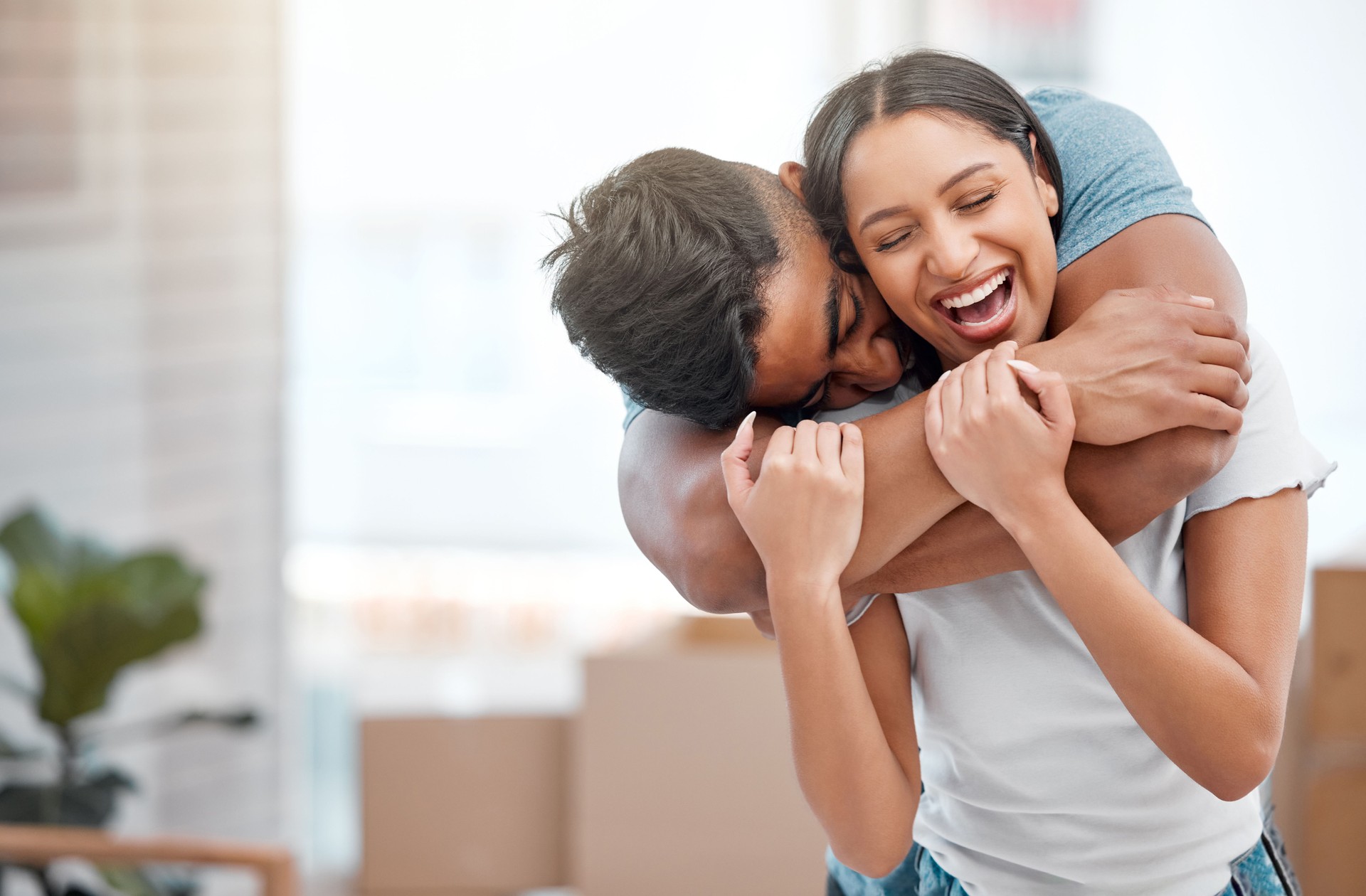 Shot of a young man feeling playful and hugging his girlfriend in their new home