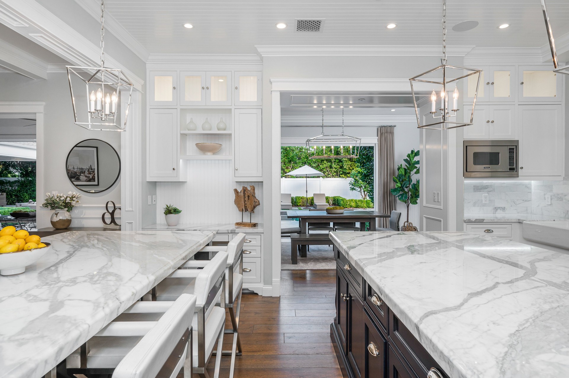 Marble kitchen with a white island, and chairs in a new construction home in Encino, California