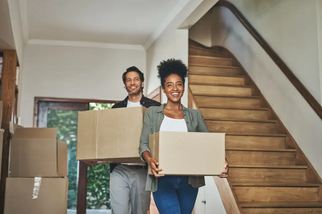 First-time home buyer holding house keys beside moving boxes